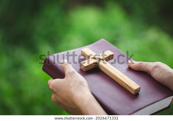 Women pray to God with the Bible and the cross of the\
morning. 