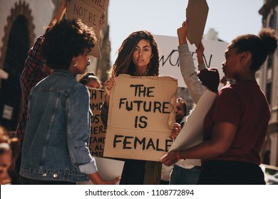 Women Protesters Hold Up Signs Of The Future Is Female. Group Of Women Protesting Outdoors For Female Empowerment.