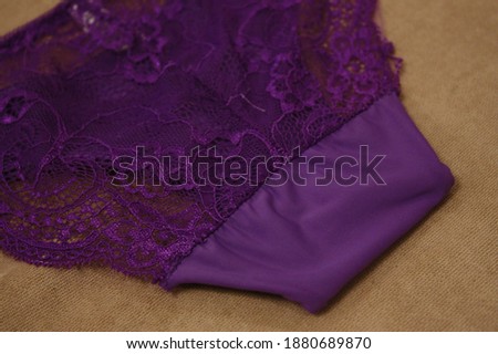 Women purple lace and smooth Bikini underwear on the brown color background.