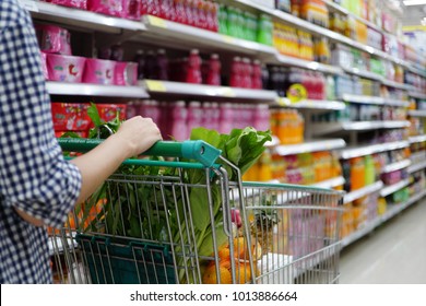Women pushing shopping trolly in the supermarket aisles, shopping concept