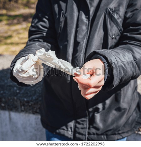 Women putting on plastic medical gloves for protection ageinst Coronavirus
