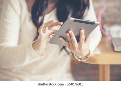 Women reading Ipad. Happy business woman using Ipad Mini reading financial article and searching for modelling on a website in university student cafe. Lifestyle technology concept.