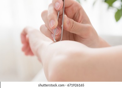 Women Removing Hair With Tweezers, Arms