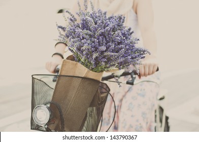 Women Riding Bike With Lavender Bouquet In Basket