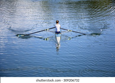 Women Rower In A Boat, Rowing On The Tranquil Lake