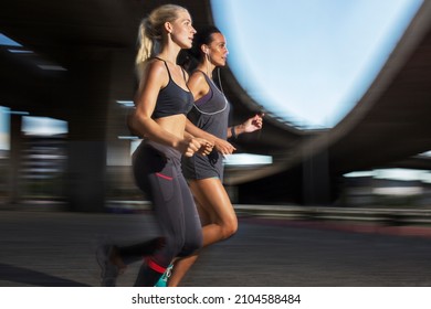 Women Running Together Through City Streets