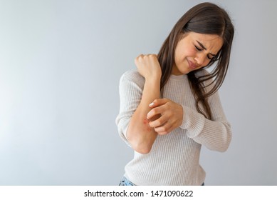 Women scratch the itch with hand , Concept with Healthcare And Medicine. Woman scratching arm on grey background. Allergy symptoms. Woman scratching her arm.