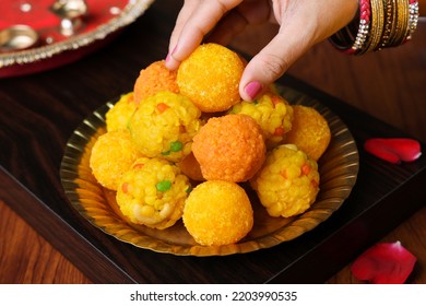 Women Serving Motichoor Ladoo Or Rava Laddu Indian Sweet Dish Mithai For Diwali Dussehra Festival