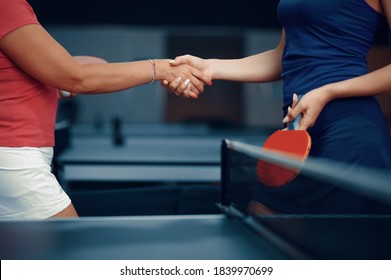 Women shake hands before table tennis match