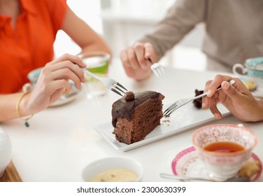 Women sharing slice of cake - Powered by Shutterstock