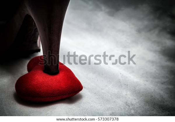 women shoes\
stomp on broken heart in dark tone., unrequited love., love concept\
for valentine\'s day., in dark\
tone.