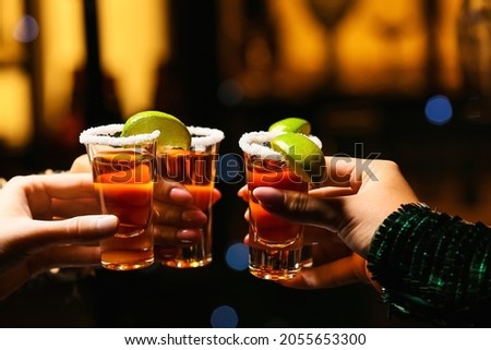 Women with shots of tasty tequila in bar, closeup