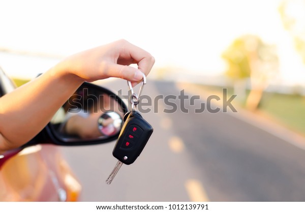 Women\
show the car keys outside the car window\
happily.