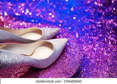 Women silver and pink glitter stylish high heel shoes on pink background. 