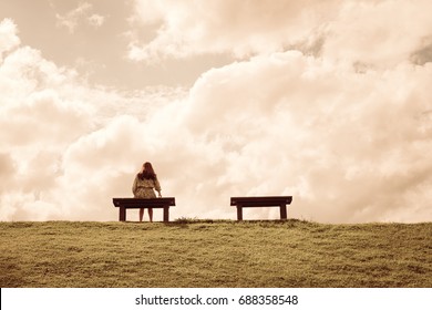 a women sitting alone on a bench waiting for love, alone concept - Shutterstock ID 688358548