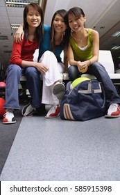 Women Sitting Side By Side In Bowling Alley, Portrait