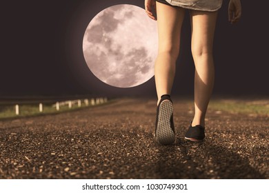 A Women And Sneaker Shoes Walking Under Full Moon At Night