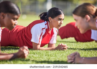 Women soccer players in a team doing the plank fitness exercise in training together on a practice sports field. Healthy female group of young athletes doing a core strength workout using teamwork - Powered by Shutterstock