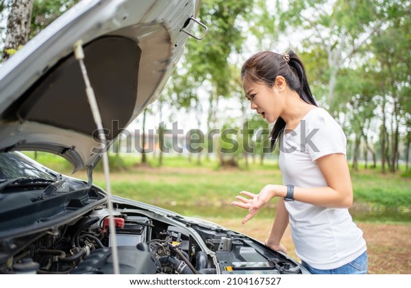 Women spection. She opened the
hood Broken car on the side See engines that are damaged or
not.