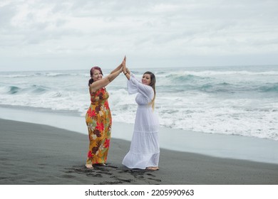 Women Spending Quality Time Together At The Beach. Mother And Daughter Enjoying Quality Time At The Beach. Pacific Ocean, Cloudy Day.