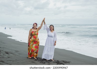 Women Spending Quality Time Together At The Beach. Mother And Daughter Enjoying Quality Time At The Beach. Pacific Ocean, Cloudy Day.