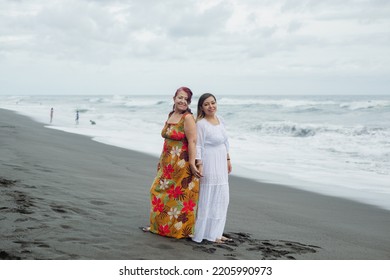 Women Spending Quality Time Together At The Beach. Mother And Daughter Enjoying Quality Time At The Beach. Pacific Ocean, Cloudy Day.