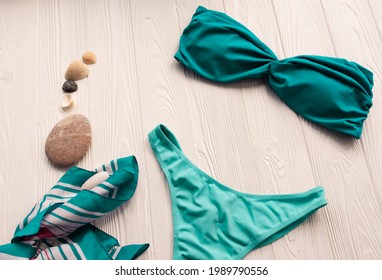 Women split multicolor blue swimsuit bikini. Summer background mockup template. pattern top view above swimwear white wooden background. accessories clothes beach. Women summer design vacation