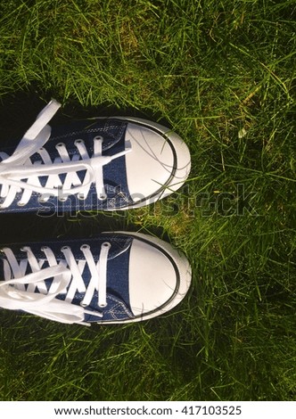 Women sport denim shoes on green grass background
