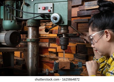 Women standing is craft working drill wood at a workbench with Drill Press power tools at carpenter machine in the workshop - Powered by Shutterstock