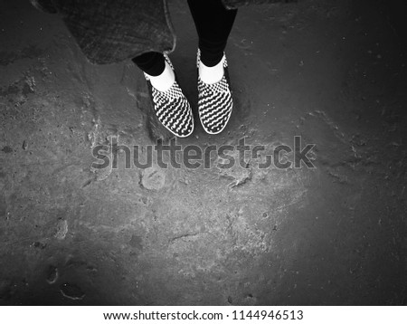 Women standing with her Black and white striped shoes on grunge black and white background on the boat on the holiday with copy space for text