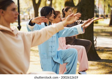 Women standing on one leg during tai chi lesson - Powered by Shutterstock