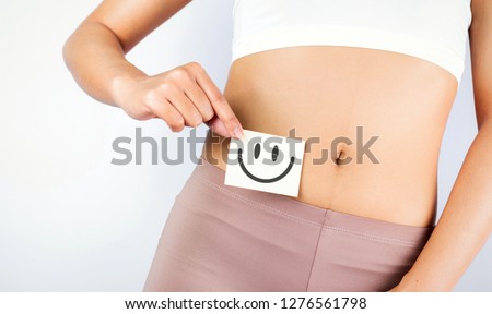 Women Stomach Health. Healthy Female With Beautiful Fit Slim Body  Holding White Card With Happy 
Smiley Face In Hands Good Digestion Concepts. High Resolution
