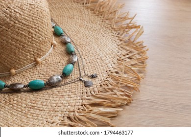 women straw hat, vintage turquoise beads and a silver shell pendant lie on a wooden table, summer accessories - Powered by Shutterstock