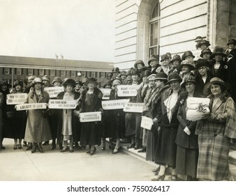 Women Suffragettes holding placards with political activist slogans in 1920. Signs read: Know Your Courts-Study Our Politicians; Liberty in Law; Law Makers Must Not Be Law Breakers; Character in Candi