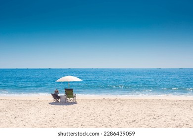 Women in sun hat on the beach enjoy summer seaside landscape. Blue ocean scenic view background. Holiday season sea travel. Sea relax tourist in busan at Haeundae beach.