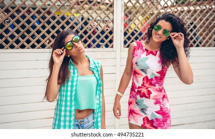 Women With Sunglasses Looking At Camera Over Garden Fence