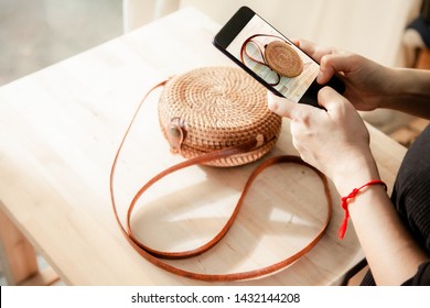 Women taking photo to Bags and products with cell telephone or smartphone digital camera for Post to sell Online on the Internet .
