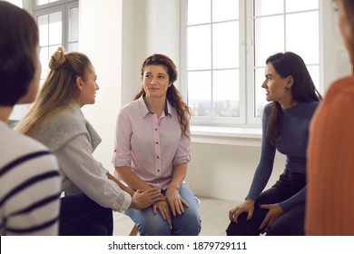Women talking and dealing with problems in therapy session. Young females discussing their life situations, giving advice, helping cope with divorce and cheering each other up in support group meeting - Shutterstock ID 1879729111