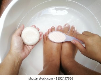 Women tan skin put their feet soaked in a bath and polished before cleaning the toenails for good health. - Powered by Shutterstock