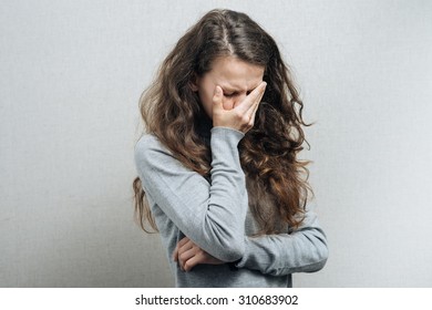 Women Think With A Sad Face. On A Gray Background.