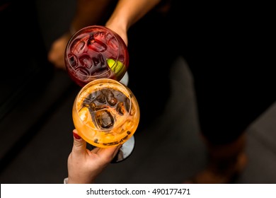 Women toasting with colorful drinks