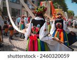 Women in traditional regional Polish costumes showing off big wool dresses during religious procession at Łowicz, Poland, on Corpus Christi