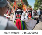 Women in traditional regional Polish costumes showing off big wool dresses during religious procession at Łowicz, Poland, on Corpus Christi