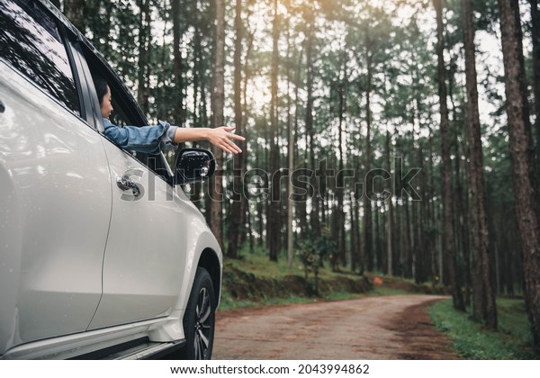 Women travel relax in\
the holiday. Traveling by car park. happily With nature, rural\
forest. In the summer. Woman travelling in the nature in free time\
on holiday with happy.