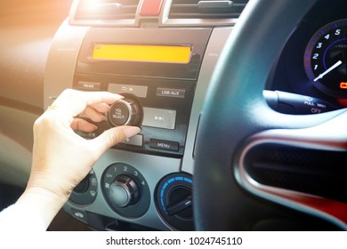 Women Turning Button On Car Radio For Listening To Volume Music