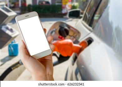 Women Use Mobile Phone ,  Image Of Car Refueling On Petrol Station And Fuel Pump With Gasoline  In The Background.