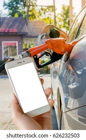 Women Use Mobile Phone ,  Image Of Car Refueling On Petrol Station And Fuel Pump With Gasoline  In The Background.