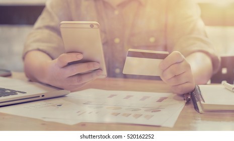 Women using Credit card verifies account balance on  mobile banking application.Online payment  shopping,selective focus,vintage color
