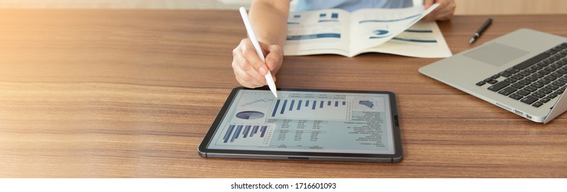 women using digital tablet with financial report spreadsheet on screen for business and marketing research evaluation performance. wide view.