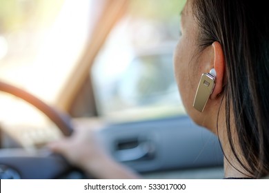 Women using hands-free phone while driving a car.